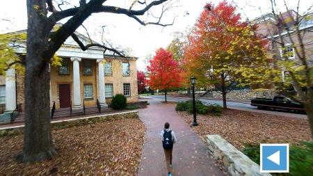 Drone-captured image of a person walking through fall foliage on the campus of UNC-Chapel Hill.